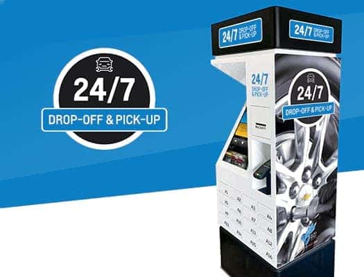 24/7 drop-off and pick-up kiosk for vehicle services, featuring a modern design and user-friendly interface, located against a blue background.